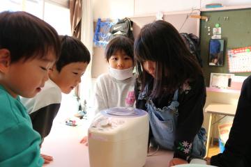 精米機で精米するのを見守る子ども達